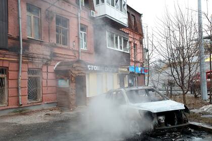Un automóvil destruido en el centro de la ciudad cerca del edificio de la Ópera de Kharkiv, que también resultó dañada, después del bombardeo de las tropas rusas.