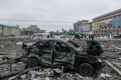 Un automóvil dañado se encuentra en la plaza central luego del bombardeo del edificio del Ayuntamiento en Kharkiv