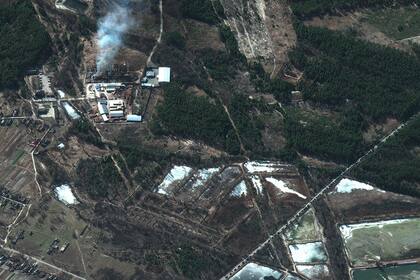 Esta imagen de satélite Maxar tomada el 28 de febrero, muestra incendios en edificios y un convoy militar a lo largo de una carretera, al norte de Ivankiv