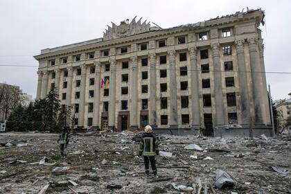 Un miembro del Servicio de Emergencia de Ucrania observa el edificio del ayuntamiento en la plaza central luego del bombardeo en Járkov