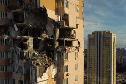 Un edificio residencial de varios pisos de altura fus alcanzado por una bomba en la parte superios causando graves daños