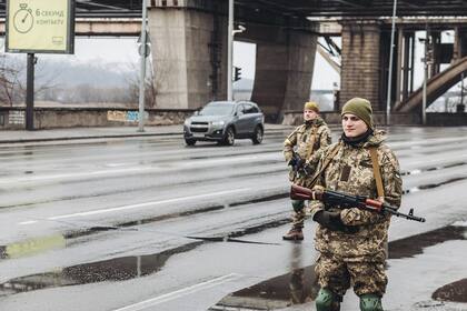Dos milicianos ucranianos controlan una carretera, a 2 de marzo de 2022, en Kiev. 