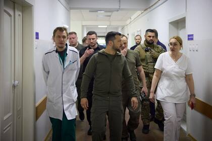 En esta foto proporcionada por la Oficina de Prensa Presidencial de Ucrania, el presidente ucraniano Volodimir Zelensky visita un hospital de la ciudad con personas que sufren de inundaciones en Kherson, Ucrania, el jueves 8 de junio de 2023. 