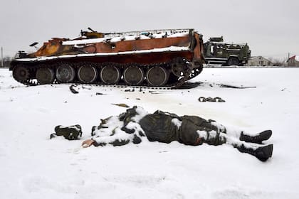 El cuerpo de un militar ruso yace en la nieve  cerca de vehículos militares destruidos al borde de una carretera en las afueras de Kharkiv .Las fuerzas ucranianas rechazaron un ataque ruso en Kyiv, pero "grupos de sabotaje" se infiltraron en la capital, dijeron funcionarios el 26 de febrero