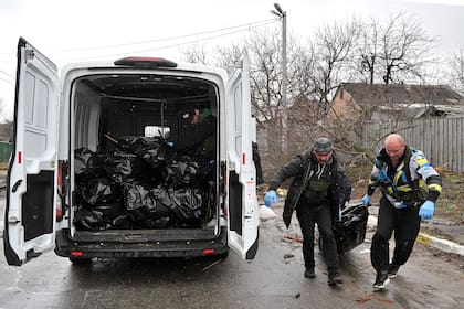 Trabajadores comunales cargan cuerpos de ucranianos en un camioneta en Bucha. Los líderes de Estados Unidos y la OTAN expresaron conmoción y horror ante las nuevas pruebas de atrocidades contra civiles en Ucrania