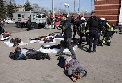 El personal de emergencia camina entre personas heridas que yacen en la plataforma tras un ataque con cohetes a la estación de tren en la ciudad oriental de Kramatorsk, en la región de Donbass, el 8 de abril de 2022. 
