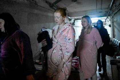 Mujeres embarazadas caminan en el sótano de un hospital de maternidad mientras las sirenas advierten de ataques aéreos en Mykolaiv, el 14 de marzo