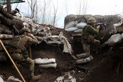 Soldados ucranianos disparan con rifles de asalto en una trinchera en la línea del frente con las tropas rusas en la región de Lugansk el 11 de abril
