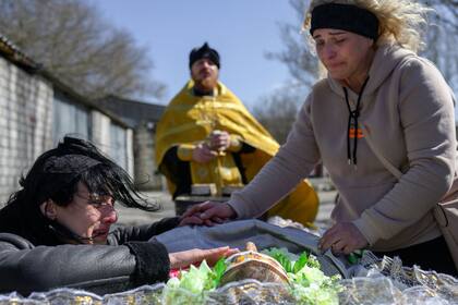 Un muejer ucraniana llora sobre el cuerpo de su esposa muerto durante los combates con las tropas rusas, durante un bombardeo en un funeral en Mykolaiv