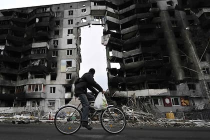 Un ciclista pasa por un edificio destruido en la ciudad de Borodianka, al noroeste de Kyiv, el 6 de abril, la retirada rusa de la semana pasada ha dejado pistas de la batalla librada para mantener el control de Borodianka, a solo 50 kilómetros de la capital