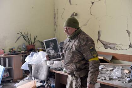 Un hombre muestra un retrato del cantante británico John Lennon dentro del ayuntamiento dañado durante un bombardeo en de Kharkiv. La plaza central de la segunda ciudad de Ucrania, Kharkiv, fue bombardeada por las fuerzas rusas que avanzaban el 1 de marzo 