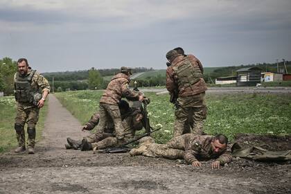 Los militares ucranianos ayudan a sus camaradas cerca de la línea del frente en la región de Donbass