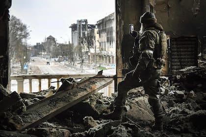 Un soldado ruso controla las calles de Mariupol desde la ventana de un teatro