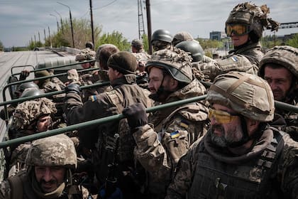 Soldados ucranianos viajan en la parte trasera de un camión a un lugar de descanso después de luchar en primera línea durante dos meses cerca de Kramatorsk