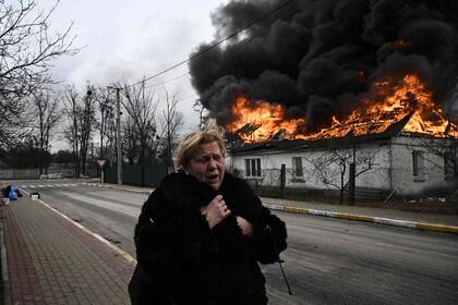 Una mujer huye de una casa en llamas en la ciudad de Kyiv. Al 4 de marzo más de 1,2 millones de personas han huido de Ucrania a los países vecinos desde que Rusia lanzó su invasión a gran escala