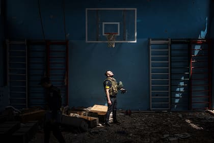 Un policía ucraniano se encuentra dentro de un pabellón deportivo escolar, donde, según los residentes, los soldados rusos tenían su base en el pueblo de Vilkhivka, después de que el ejército ucraniano lo recuperara, cerca de la ciudad oriental de Kharkiv, 13 de mayo