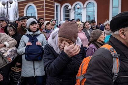Una mujer llora mientras las familias esperan para abordar un tren en la estación central de Kramatorsk mientras huyen de la ciudad oriental de Kramatorsk, en la región de Donbass, el 5 de abril