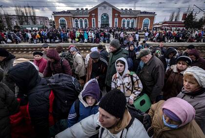 Las familias caminan en una plataforma para abordar un tren en la estación central de Kramatorsk mientras huyen de la ciudad oriental de Kramatorsk, en la región de Donbass el 5 de abril de 2022