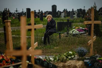 Una mujer llora mientras visita la tumba de Stanislav Hvostov, de 22 años, un militar ucraniano asesinado durante la invasión rusa de Ucrania, en la sección militar del cementerio Kharkiv número 18 en Bezlioudivka