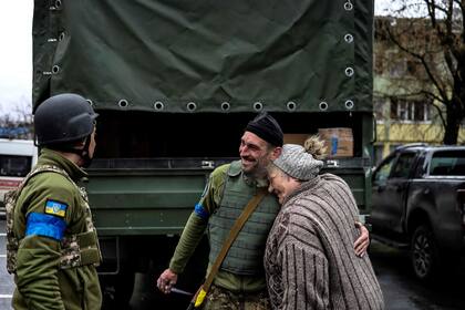 Una anciana abraza a un soldado ucraniano en Bucha, al noroeste de Kyiv, donde el alcalde de la ciudad dijo que 280 personas habían sido enterradas en una fosa común y que la ciudad estaba llena de cadáveres. - Ucrania ha recuperado el control de "toda la región de Kyiv" después de que las fuerzas invasoras rusas se retiraran de algunas ciudades clave cerca de la capital ucraniana