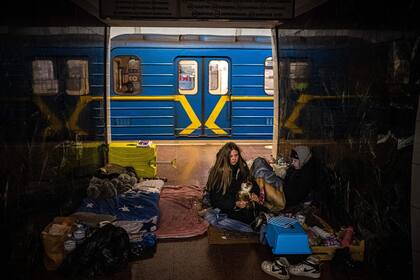 Una mujer abraza a su gato dentro de un vagón de metro en una estación subterránea utilizada como refugio antiaéreo en Kyiv el 8 de marzo.  El presidente de Ucrania, Volodymyr Zelensky, prometió "luchar hasta el final"