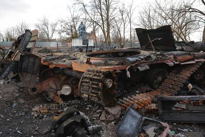 A tank, damaged by fighting between Russian and Ukrainian troops in Lukyanivka, Kyiv region, Ukraine, Monday, March 27, 2022. The memorial for the residents of Lukyanivka killed during Great Patriotic War 1941-1945 (WWII) is seen in the background, also damaged. (AP Photo)