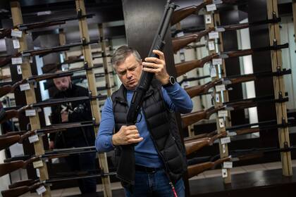 Un cliente revisa su rifle en una tienda de armas en Lviv, en el oeste de Ucrania. El Ejército ruso está haciendo frente a toda una nación en armas, civiles y militares 