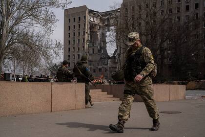 Un soldado ucraniano pasa frente a la sede del gobierno regional de Mykolaiv, Ucrania, luego de un ataque ruso, el martes 29 de marzo de 2022