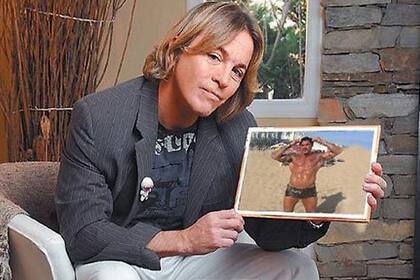 Guido Süller, en una entrevista, junto a un retrato de Ricardo Fort. Ambos eran muy amigos desde la adolescencia