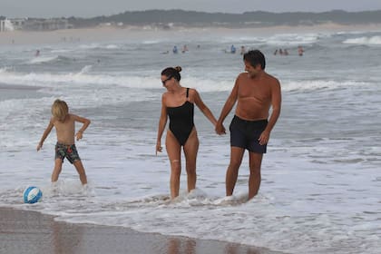 Guillermo Andino, Carolina Prat y su hijo Ramón en un día de playa. Mientras la pareja camina tomada de la mano, el pequeño muestra sus habilidades con la pelota.