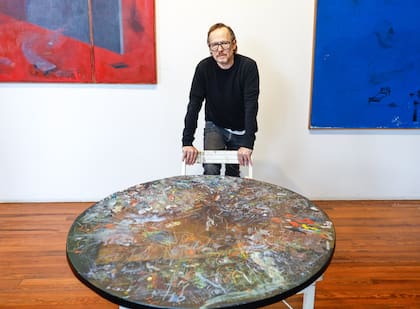 Guillermo Kuitca, con la mesa, la silla y el último de los "Diarios" que cierra la serie que se expone en Arthaus desde el 28 de abril