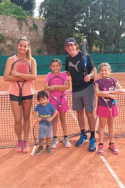 Guillermo Vilas posa orgulloso en una cancha con sus cuatro hijos.