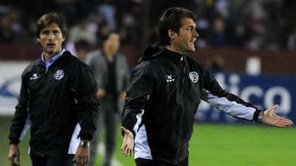 Guillermo y Gustavo, como técnicos de Lanús; de fondo, el Muñeco en River