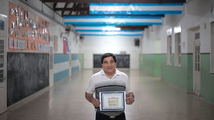 Gustavo Ballas posa con su diploma de graduado luego de la ceremonia de graduacion, Villa María