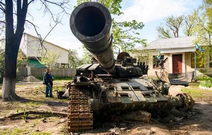Habitantes locales junto a un tanque ruso destruido en Sloboda, en la ciudad de Chernígov, en el norte de Ucrania en mayo.