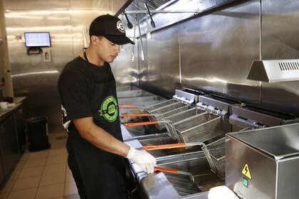 Hacer papas fritas es parte del trabajo de Braian