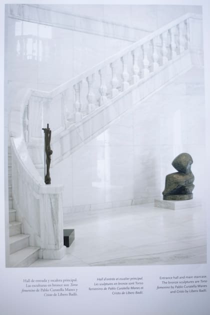 Hall de entrada principal  y la escalera, de mármol blanco, con un crucifijo y un busto de mujer de Pablo Curatella Manes. (foto: Libro "La Torcaza")