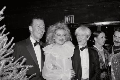 Halston junto a Andy Warhol y la socialité Cornelia Guest en una fiesta en Nueva York circa 1983.