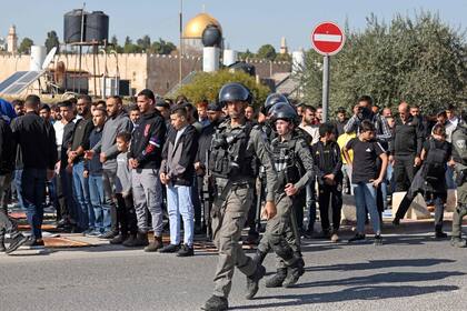 Fuerzas israelíes patrullan la zona mientras musulmanes palestinos realizan la oración del mediodía del viernes en la calle en el barrio de Ras al-Amud, en Jerusalén oriental, el 1 de diciembre de 2023.
