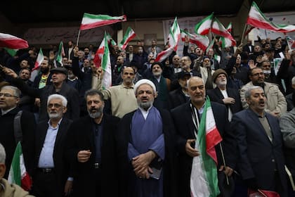 Hamid Rasaee (centro), un clérigo musulmán chiíta iraní y exmiembro de la Asamblea Consultiva Islámica, asiste a un mitin de campaña electoral en un estadio deportivo (Photo by ATTA KENARE / AFP)