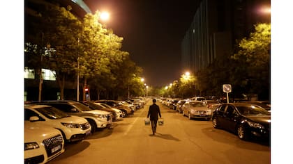 Han Liqun, un gerente de Recursos Humanos de Renren Management Co., lleva cerveza y comida para sus colegas a la oficina después de la medianoche