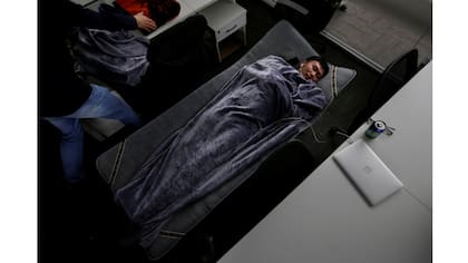 Han Liqun,un gerente de Recursos Humanos de Renren Management Co., duerme en una cama plegable en la oficina después de terminar el trabajo temprano en la mañana