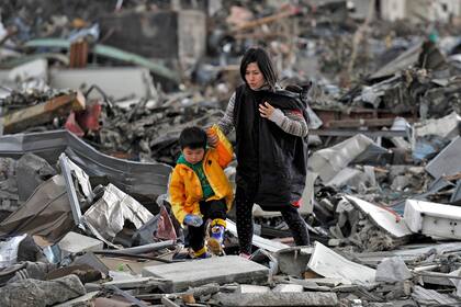 Haruto Asanuma, de cuatro años, guía a su madre Hiroko hasta el lugar en el que se encuentran los escombros de la casa de su abuela, en Onagawa