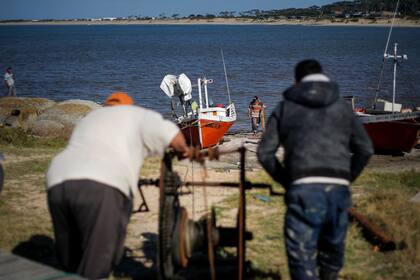 Hasta el remolque para sacar la barca del agua es manual. Mientras dos mueven la maquina, otro va colocando debajo de la embarcación maderas y tubos de metal para que ruede hacia tierra firme