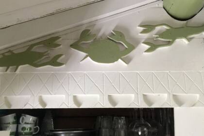 Hay alegres tallas de cangrejos de río en el área de la cocina, y estantes llenos de productos de limpieza y aerosoles para insectos