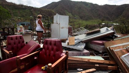 Haydee Mestre mira dentro de su refrigerador ,su casa devastada después de que el huracán María destruyera el puente de la ciudad y sus alrededores,