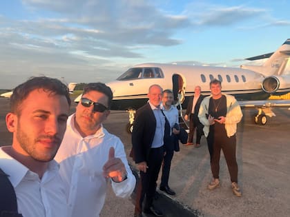Hayden Davis, de campera color crema, antes de subir a un jet durante su visita a la Argentina