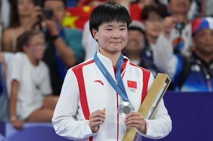 He Bing Jiao lleva un pin de España en homenaje a su colega Carolina Marín, quien se lesionó de gravedad en la semifinal de badminton.