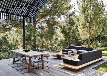 Hecha con tirantes de madera de formas irregulares, la pérgola filtra el sol al modo de las copa de los árboles.