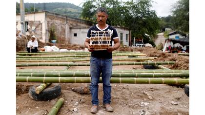 Héctor Guzmán, de 48 años, campesino y representante del Presidente Municipal de San José Platanar, sostiene el modelo de una casa nueva para su padre